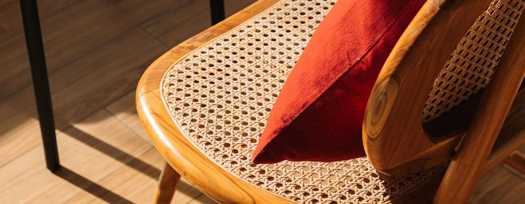 A chair with a cushion in the sunlight.