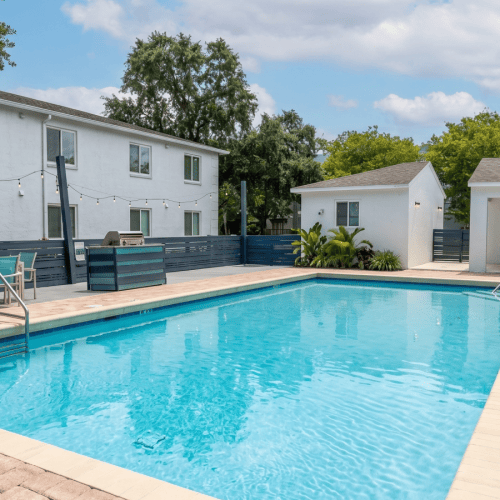 a swimming pool with table and chairs